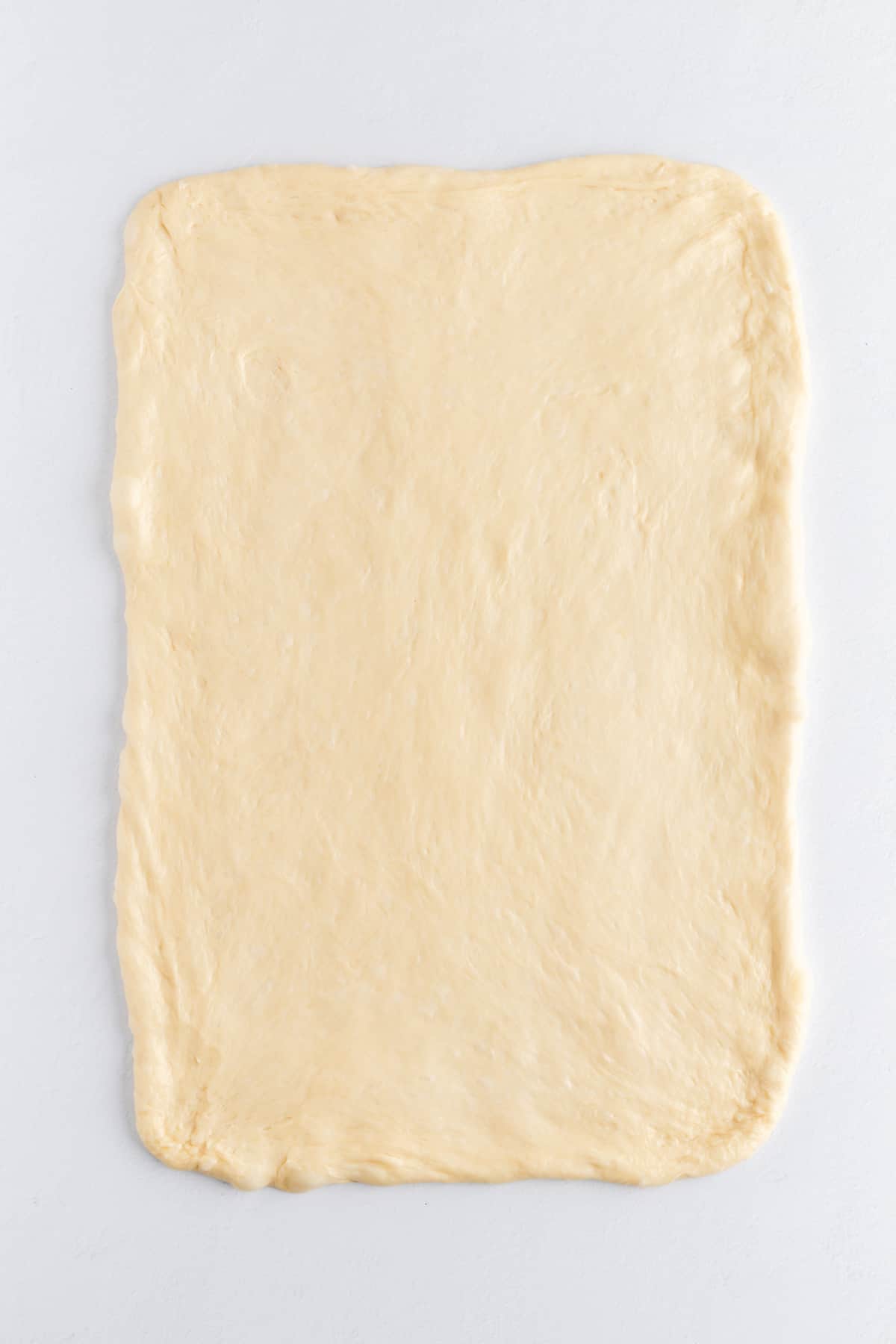rolled out brioche dough in a 12" x 18" rectangle on a white background.