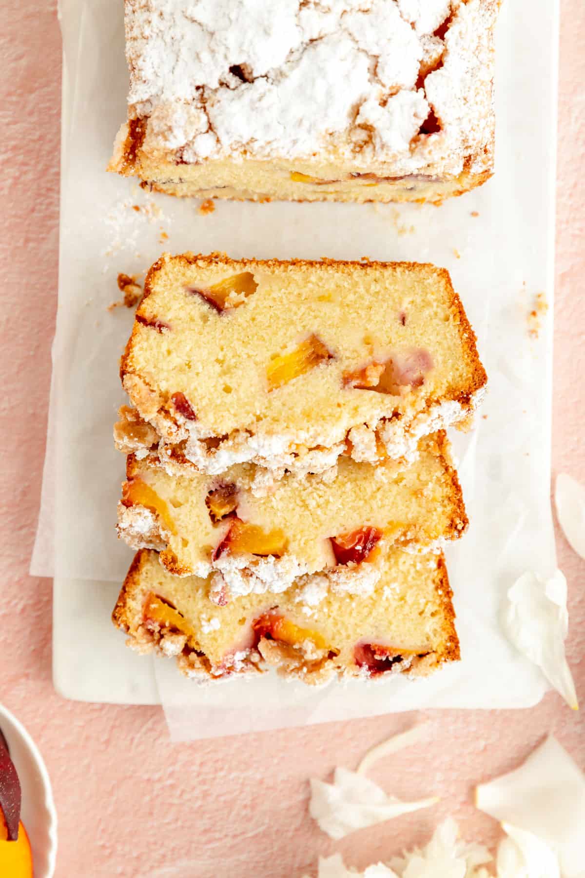 peach cobbler pound cake sliced on white board dusted with powdered sugar from overhead.