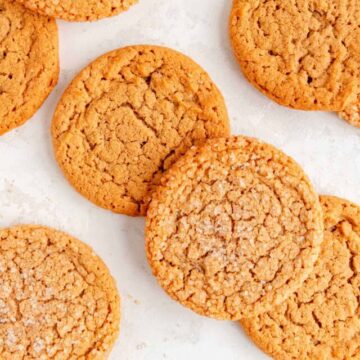 gluten free peanut butter cookies with and without sugar coating stack on white plaster background.