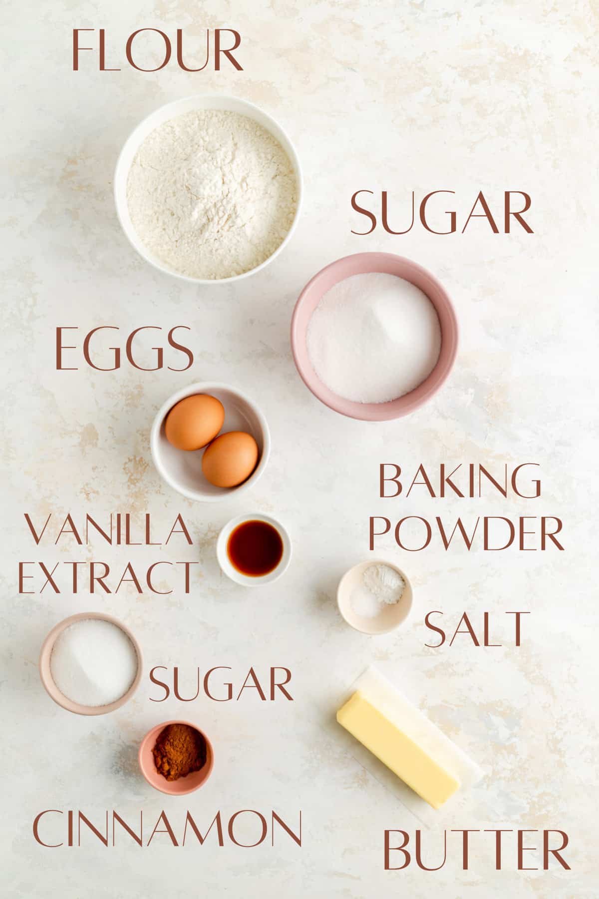 flour, sugar, eggs, baking powder, vanilla, salt, sugar, cinnamon and butter in individual bowls.