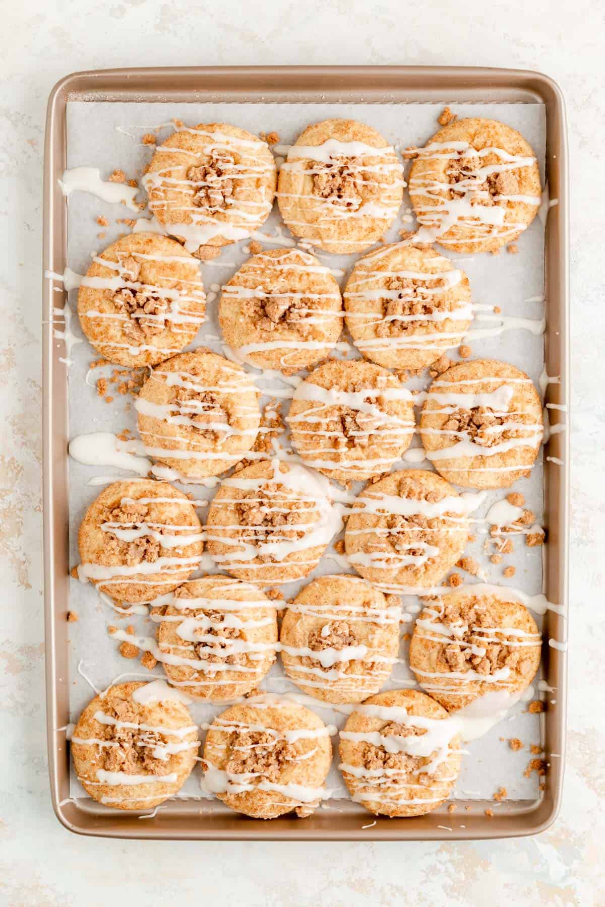 a full tray of coffee cake cookies with vanilla icing drizzled in stripes on top.