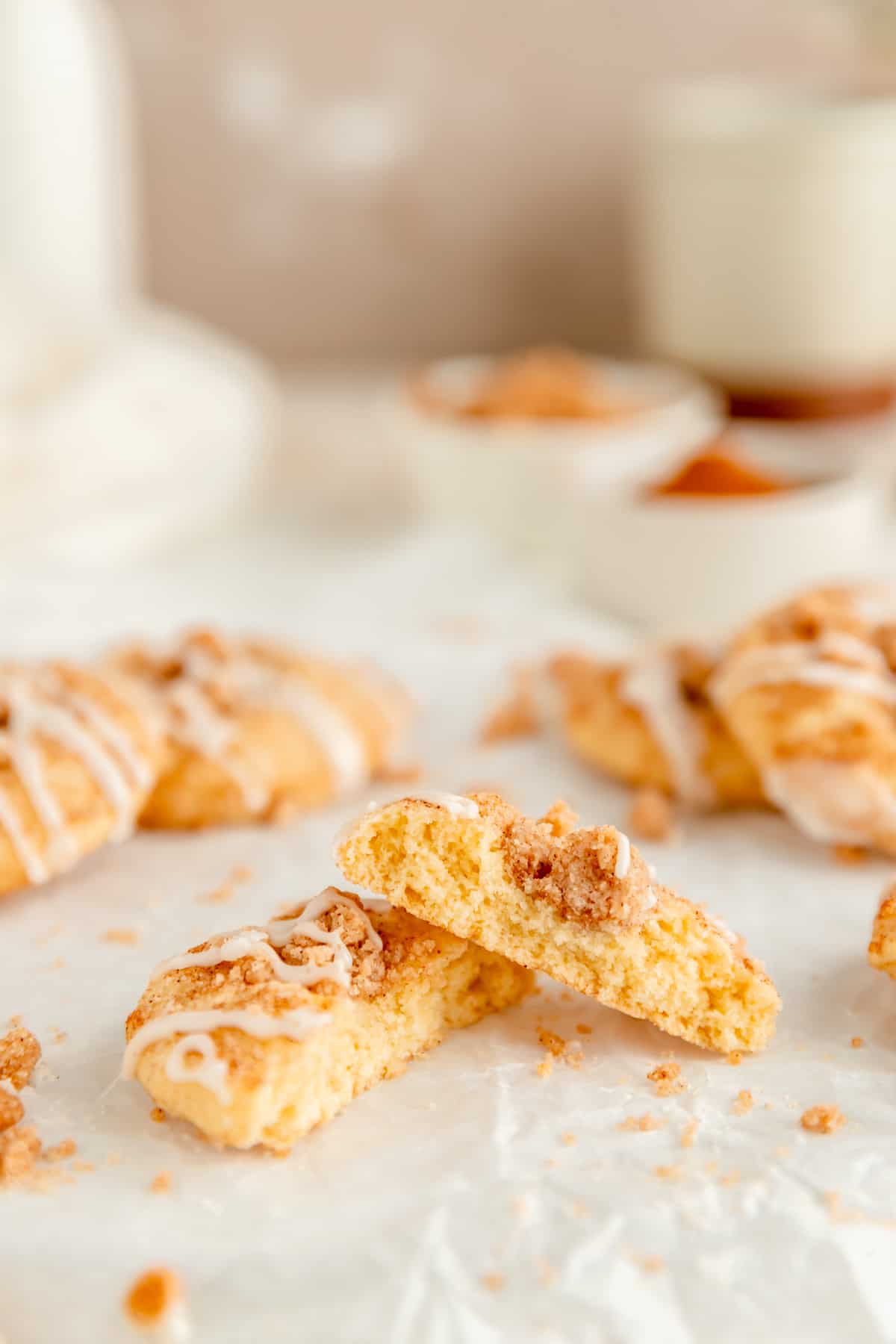 side view of a coffee cake cookie broken in half and stacked with other cookies in background.