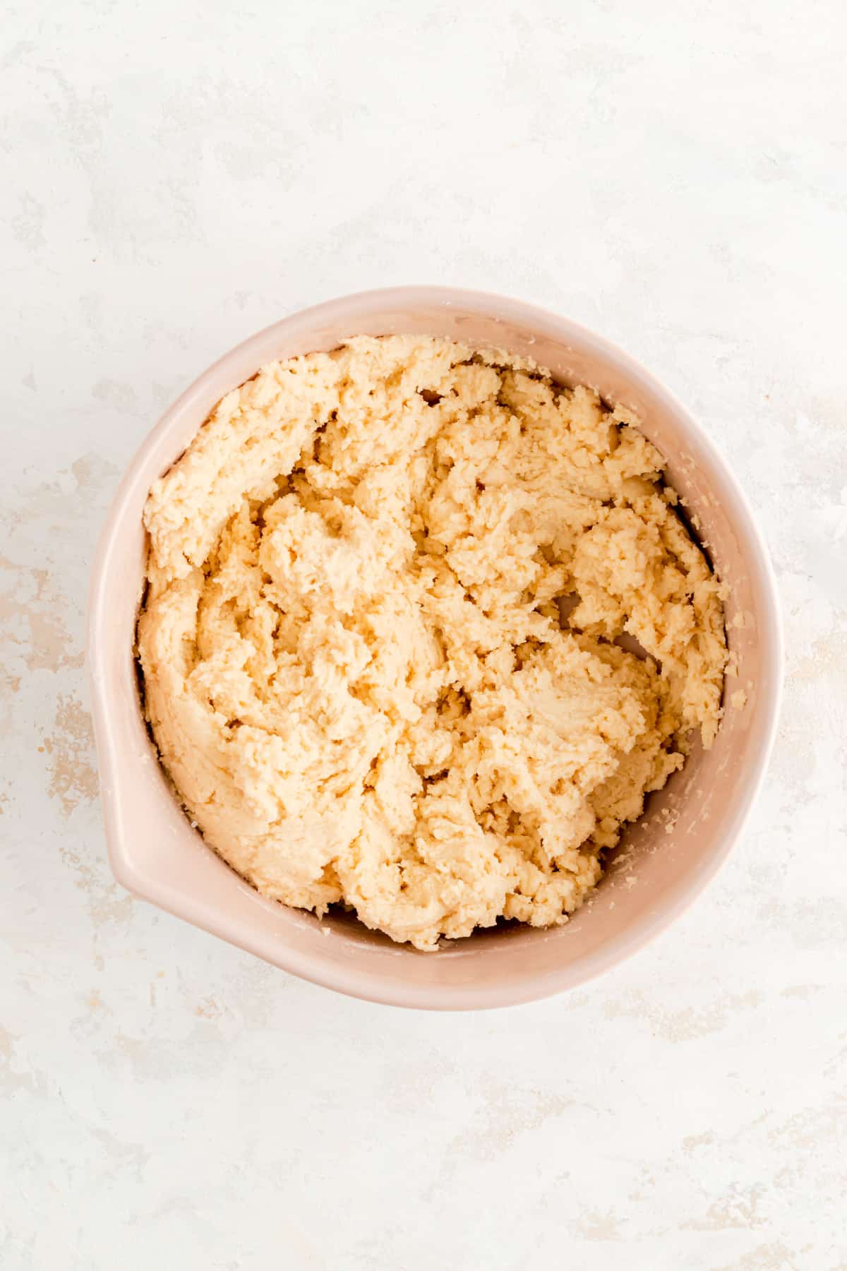 coffee cake cookie dough in a tan bowl on a white background.