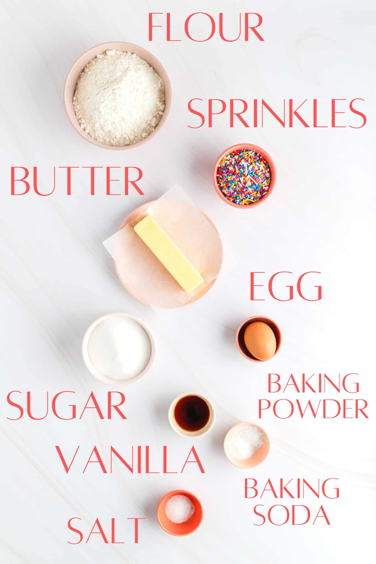 flour sprinkles butter egg sugar vanilla baking powder baking soda and salt in individual bowls.