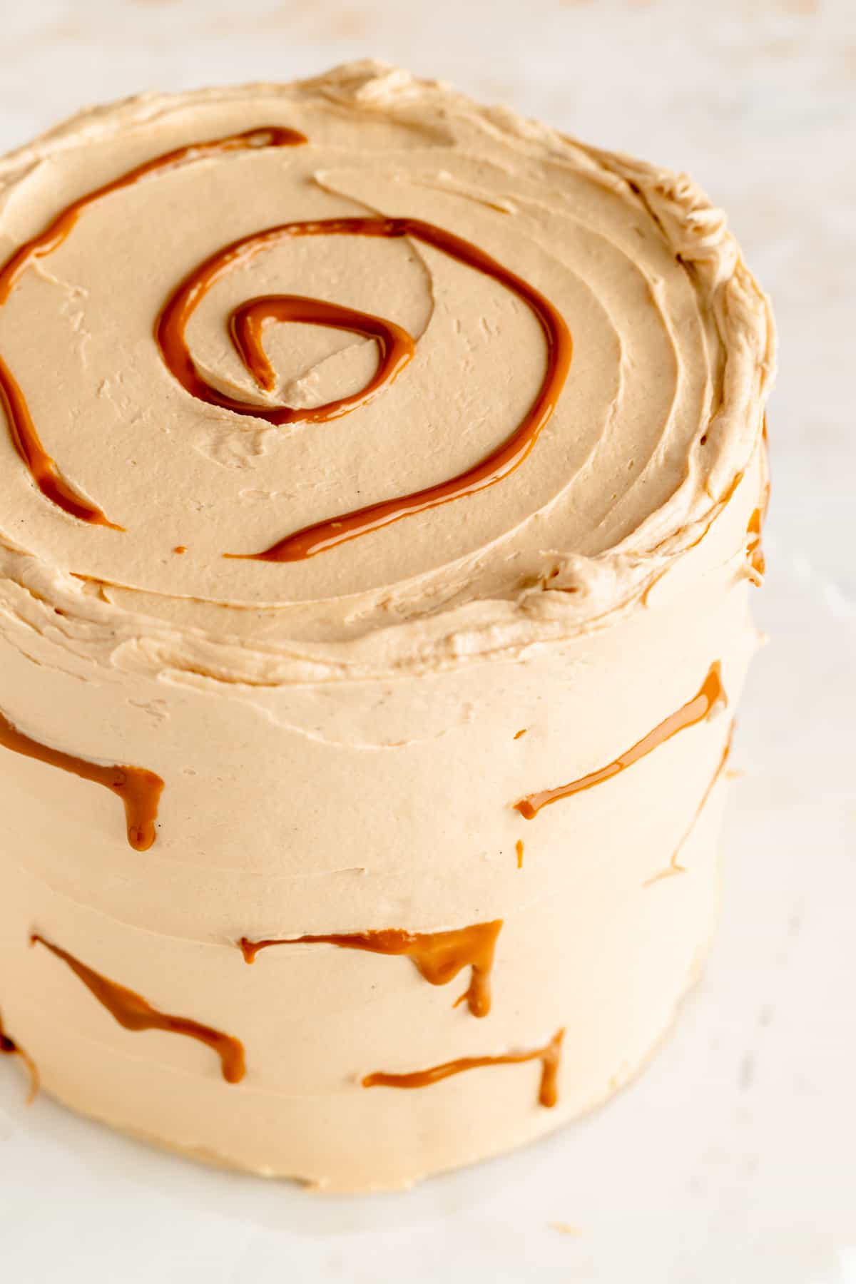Close up of Biscoff buttercream frosted cake covered in lines of piped melted Biscoff spread.