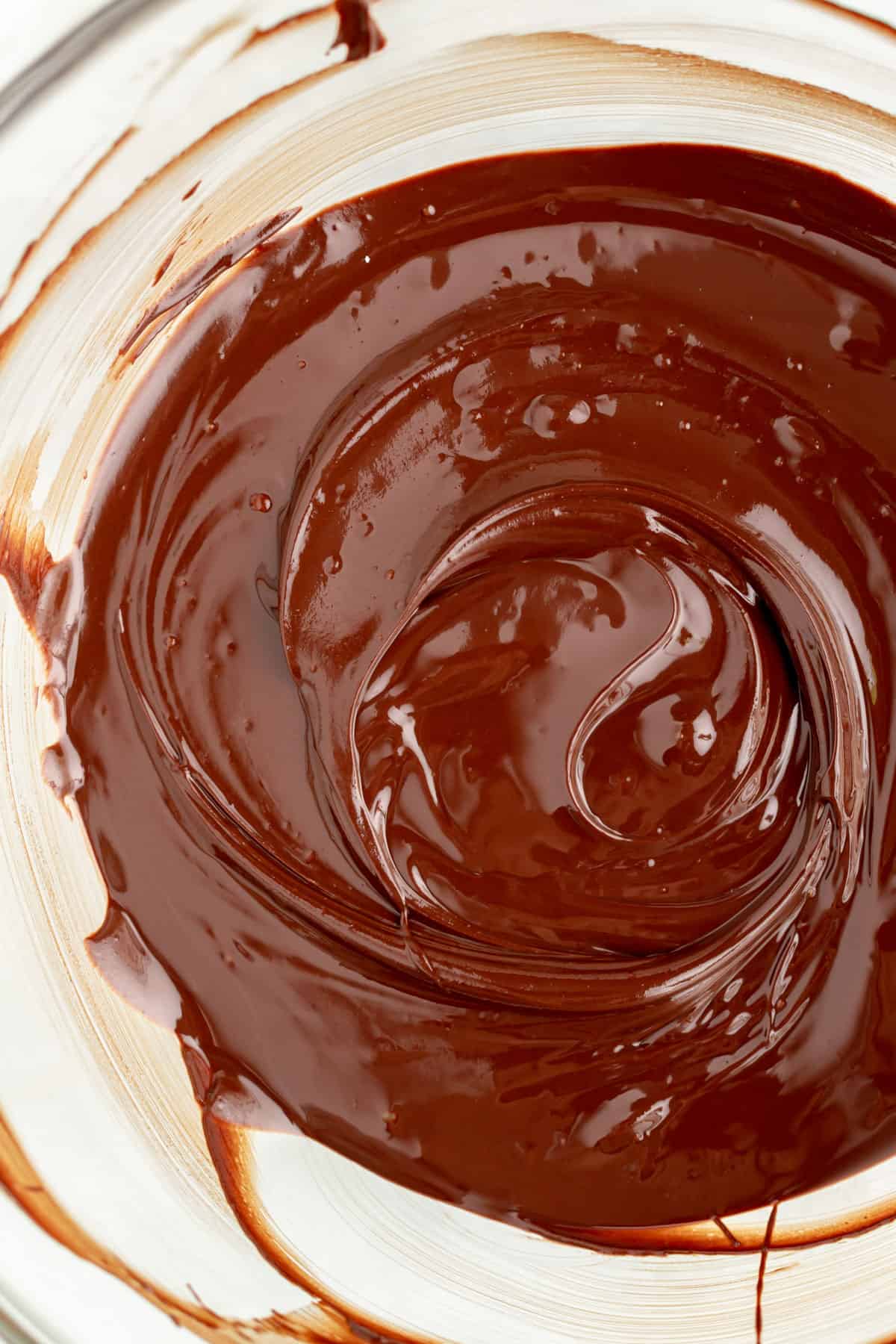 overhead close up of melted dark chocolate in a glass bowl.