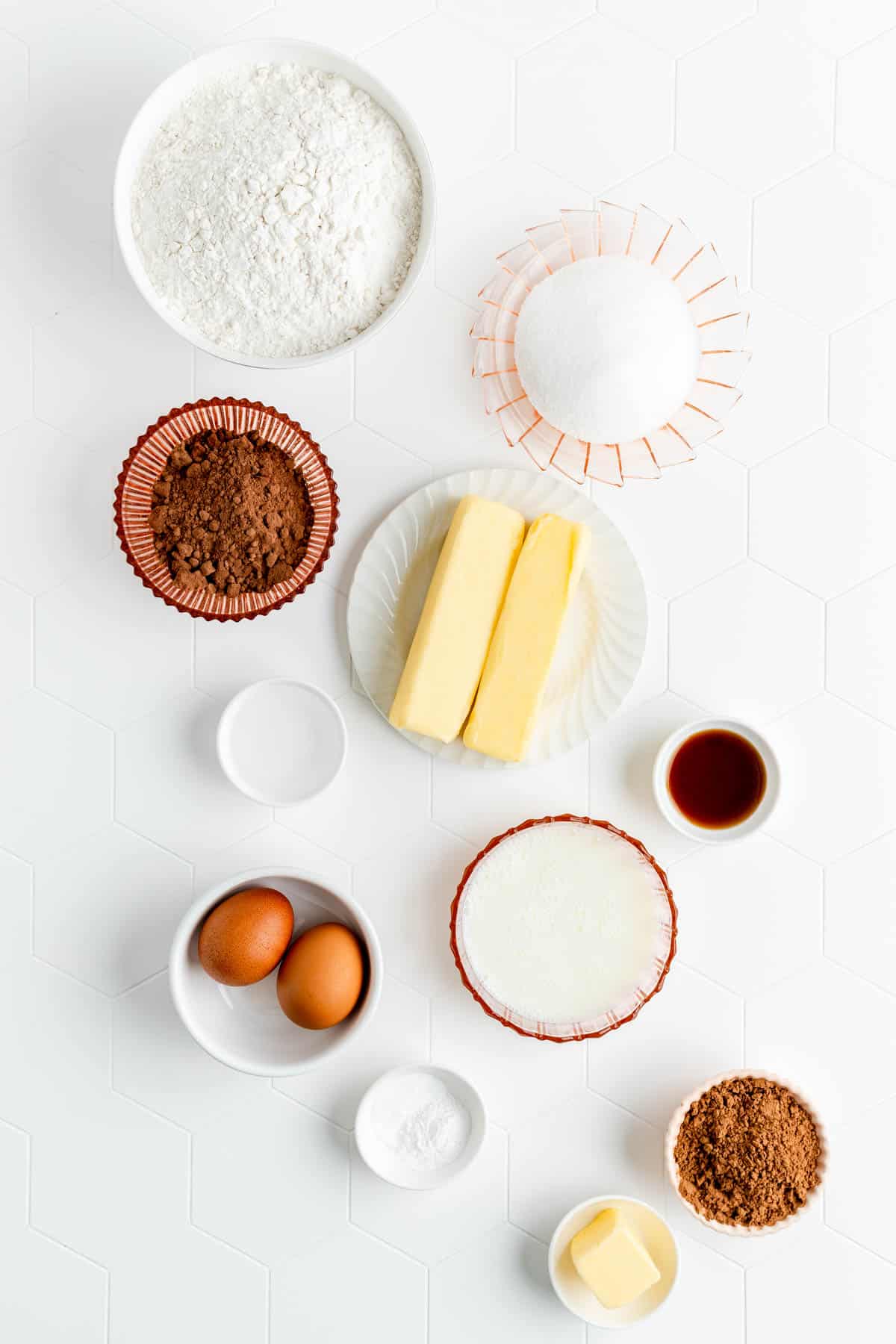 Ingredients for red velvet Bundt cake in individual bowls on white background.
