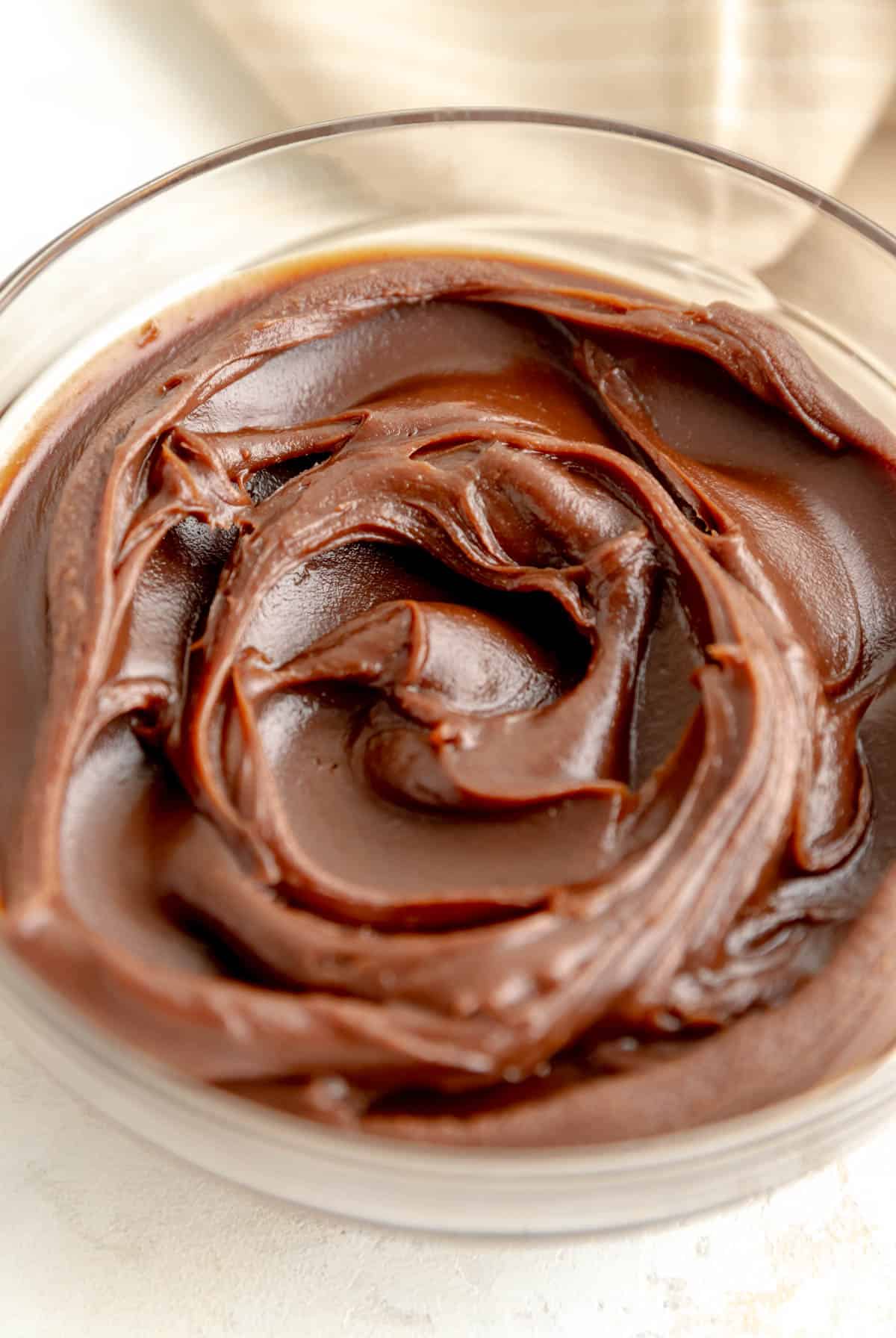 close up from top of a small glass bowl of chilled dark chocolate peanut butter ganache