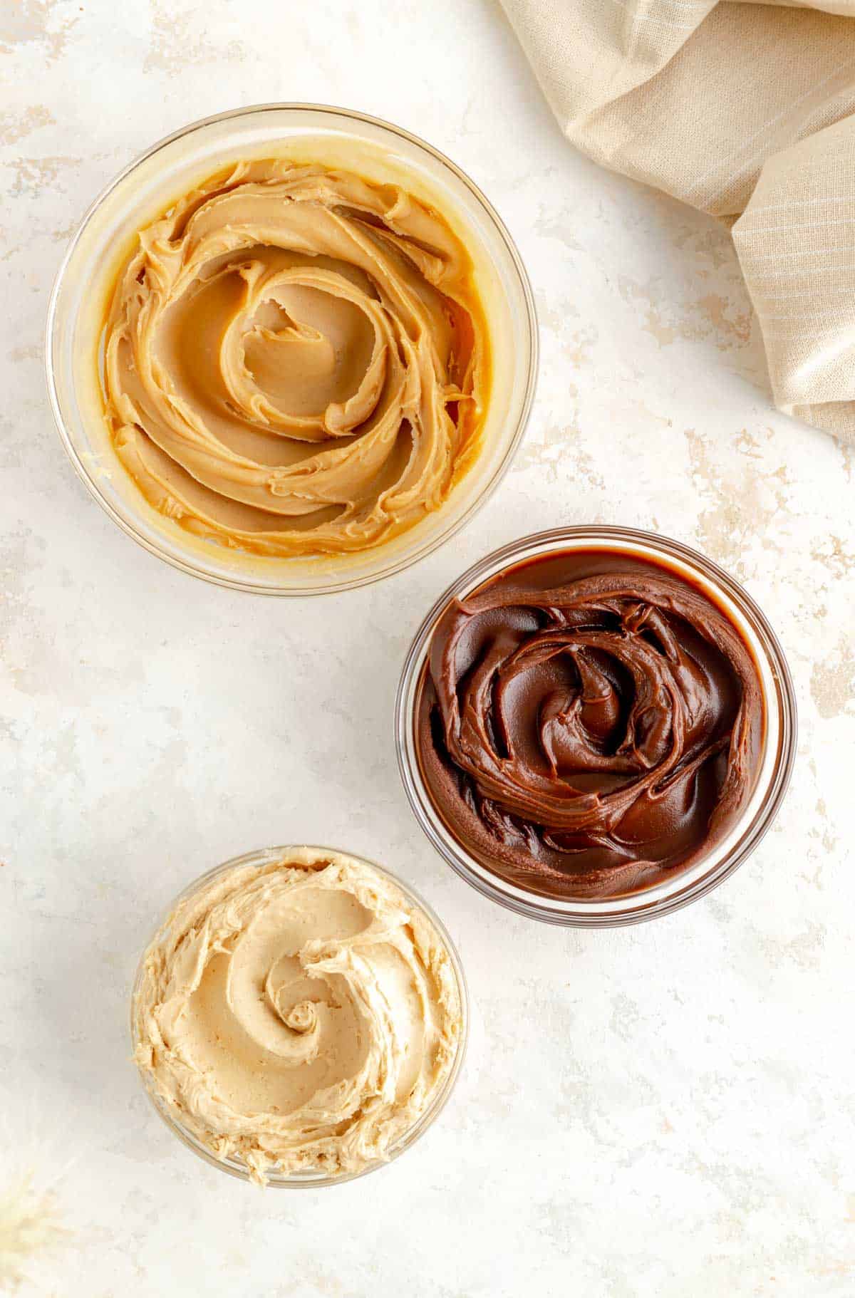 classic, dark chocolate, and whipped variations of peanut butter ganache in three glass bowls